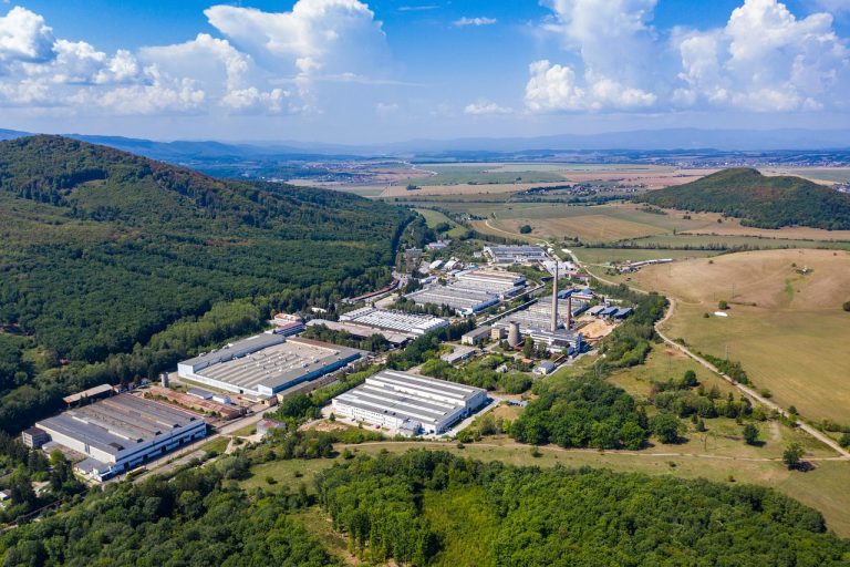 Vista panorâmica de um parque industrial, com fábricas e outros edifícios de produção integrados à paisagem urbana.